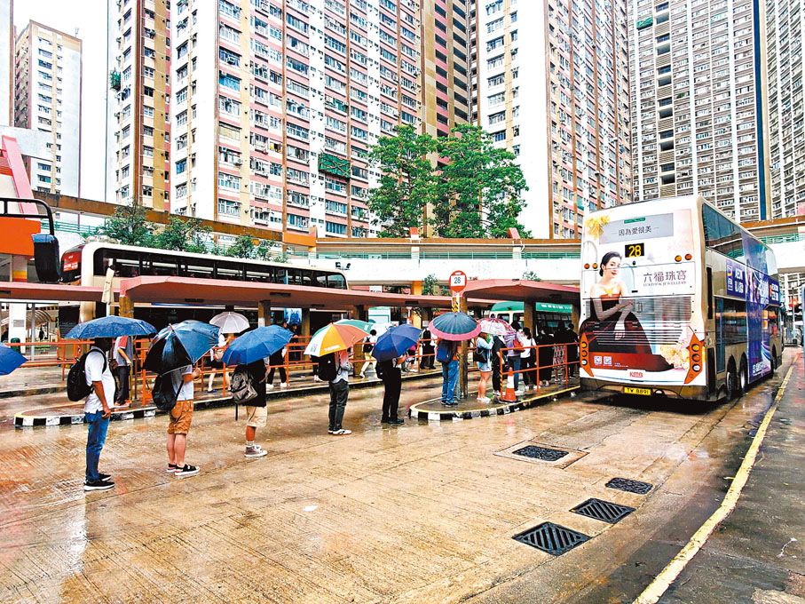◆在觀塘樂華邨巴士站，乘客冒雨排隊上車，秩序良好。香港文匯報記者郭木又、張弦、劉友光  攝
