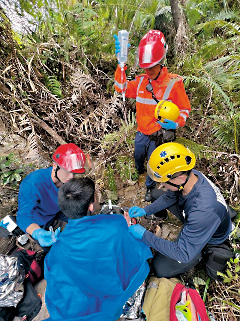 ◆救援人員為曾憲哲披上外套保暖。