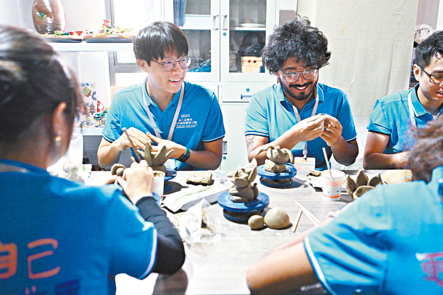 ◆戴楷臻（左一）在雲南省昆明市體驗用陶藝技藝製作「瓦貓」。