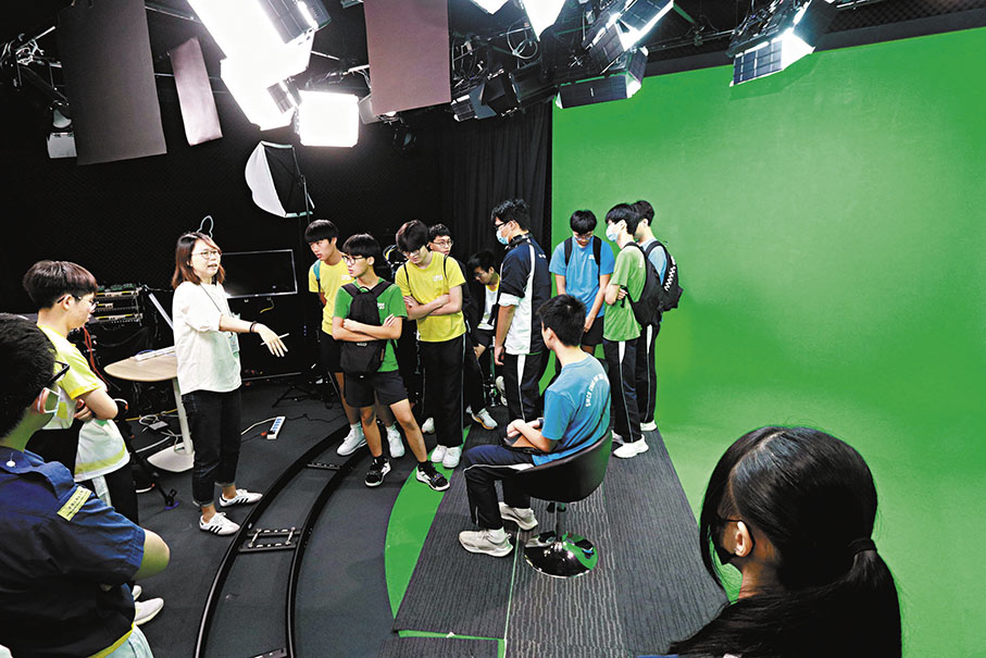 ◆同學們走近新媒體直播間，坐在主播台上，體驗現場訪談。 香港文匯報記者北山彥  攝