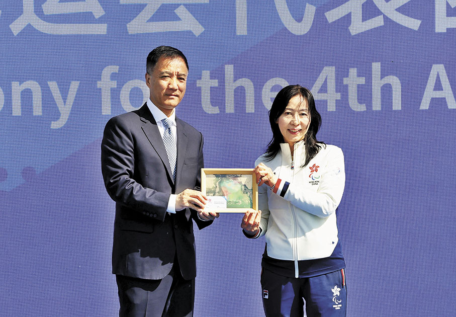 ◆香港殘奧會行政總監（右）向亞殘運村村長贈送香港學生畫作。 圖片由中國香港殘疾人奧委會提供