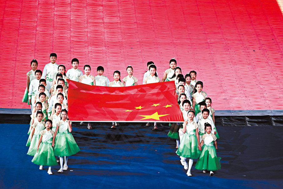◆聽障兒童手執國旗走向旗幟台。新華社