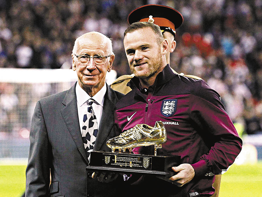 ◆2015年，卜比查爾頓(左)向朗尼頒贈英格蘭隊史神射手金靴獎座。  資料圖片