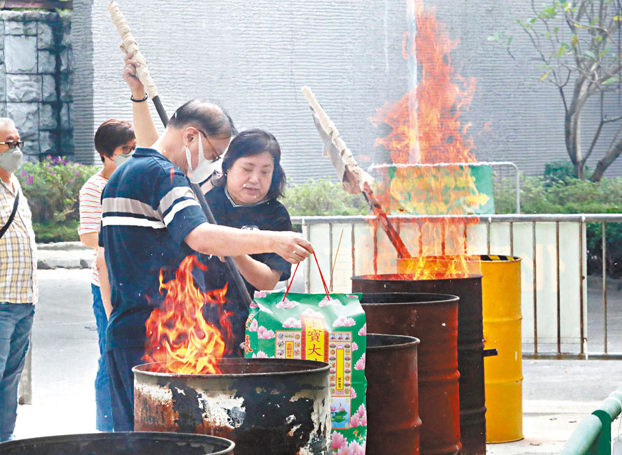 ◆ 市民攜帶元寶、冥鏹投入鐵桶。香港文匯報記者郭木又 攝