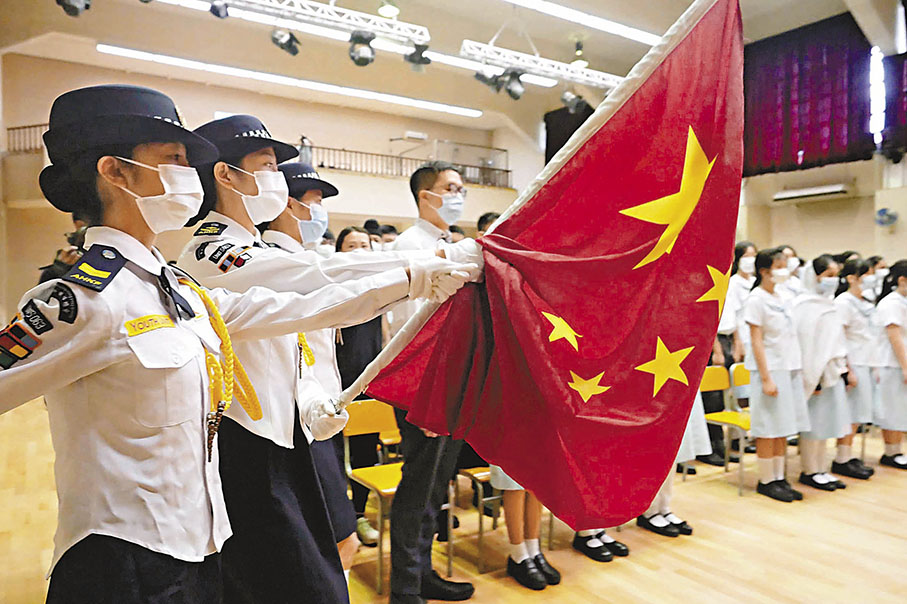 ◆十四屆全國人大常委會第六次會議10月24日表決通過《中華人民共和國愛國主義教育法》，自2024年1月1日起施行。圖為2021年香港黃楚標中學白衣藍帽護旗升旗小隊正步走向旗杆。 資料圖片