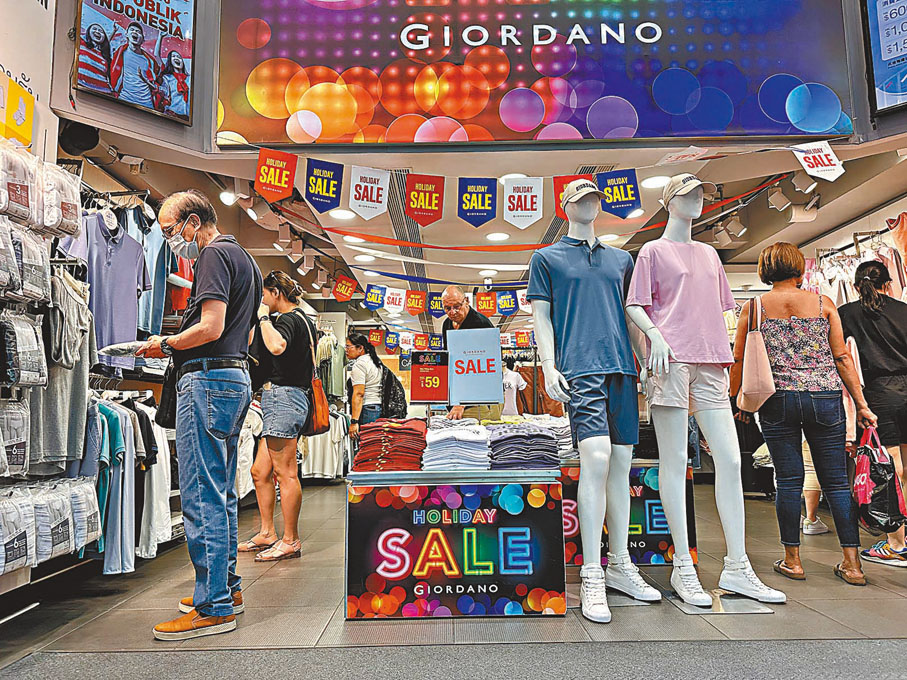 ◆政府統計處昨日公布9月零售業銷售價值臨時估計為318億元，按年升13%。圖為市民到連鎖服裝店內購物。中通社