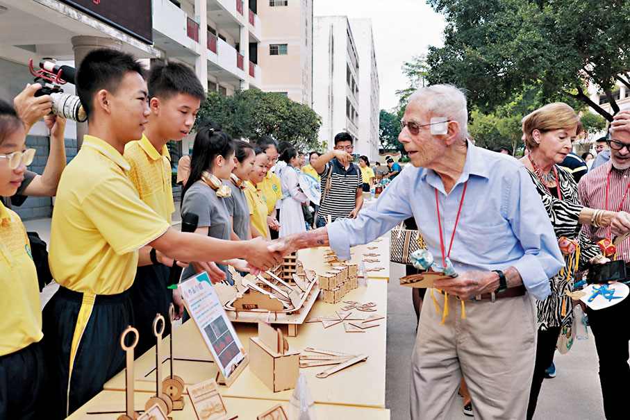 ◆11月5日，美國飛虎隊老兵哈里·莫耶、梅爾文·麥克馬倫攜飛虎隊後代訪問「飛虎隊友誼學校」—廣西柳州市壺西實驗中學。圖為哈里·莫耶與學生握手。 中新社