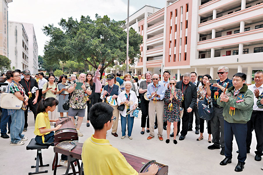 ◆中美民間的相互交往有利於促進雙方間的相互了解。圖為飛虎隊代表團觀看學生彈古箏。中通社