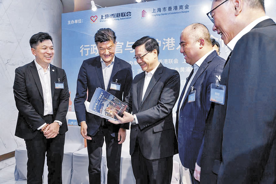 ◆李家超在上海訪問期間，在滬港人港企代表姚祖輝（左二）等向他贈送了由大公報出版有限公司出版的《踔厲前行——在滬港人上海故事》一書，受到特首充分肯定。 香港文匯報上海傳真