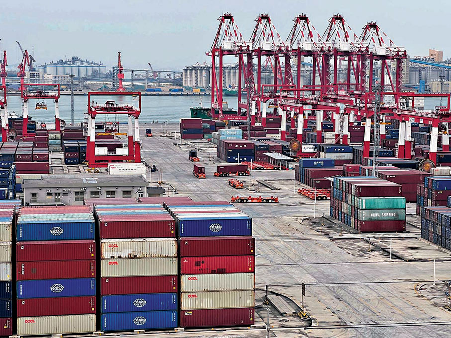 ◆員工只需坐在智控大廈的智能眼控中心辦公，就能完成碼頭設備的遠程控制。圖為南沙四期碼頭內，橙色智能導引車將集裝箱運往目標位置。香港文匯報記者帥誠  攝