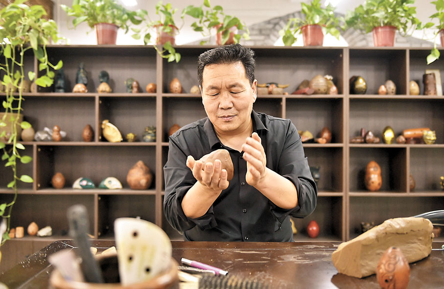 ◆王建在工作室裏製作黃河泥塤。