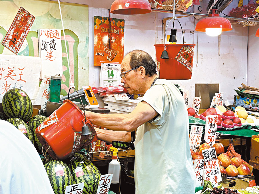 ◆生果檔已裝電子支付工具，但光顧的市民仍傾向使用現金交易。 香港文匯報記者廣濟 攝