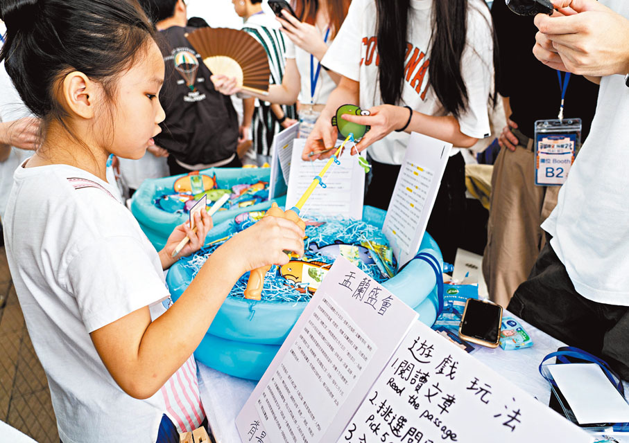 ◆青年人在市集介紹自己設計的「盂蘭勝會」小遊戲。