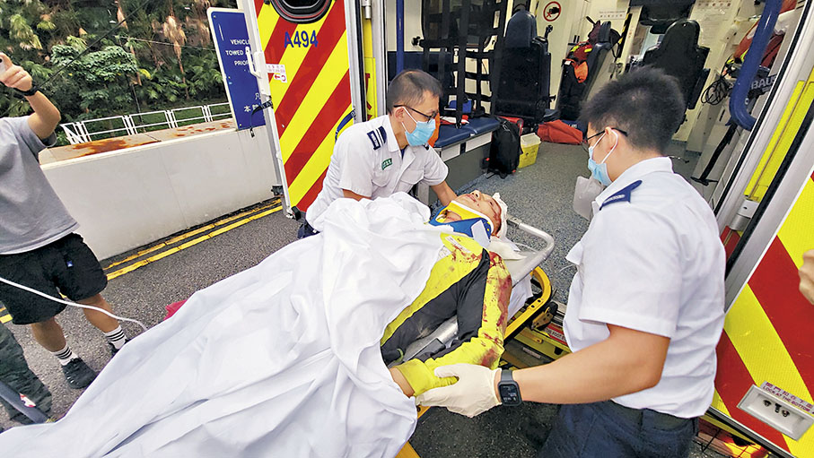 ◆一度被鋼筋壓中重傷被困的兩名工人，由消防員救出送院治理。 香港文匯報記者鄧偉明  攝