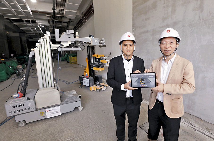 ◆房委會展示首部多功能室內建築機械人「建築三一萬能俠」，能執行批盪、打磨和噴漆的工序。 香港文匯報記者郭木又 攝