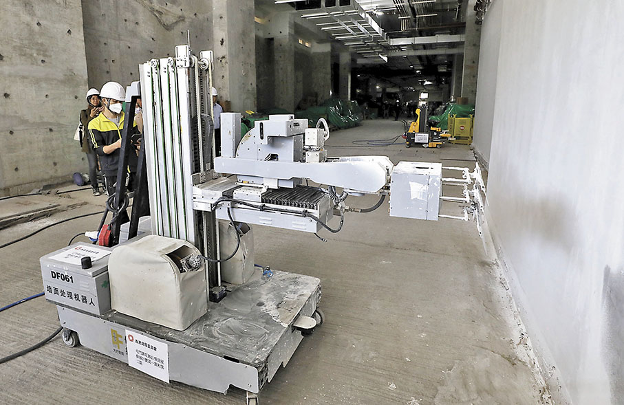 ◆大號「建築三一萬能俠」機械人示範批盪工序。 香港文匯報記者郭木又  攝