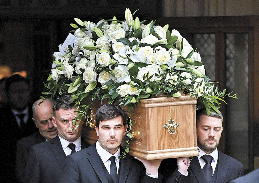 ◆扶靈隊伍將卜比查爾頓的靈柩抬離教堂。  法新社