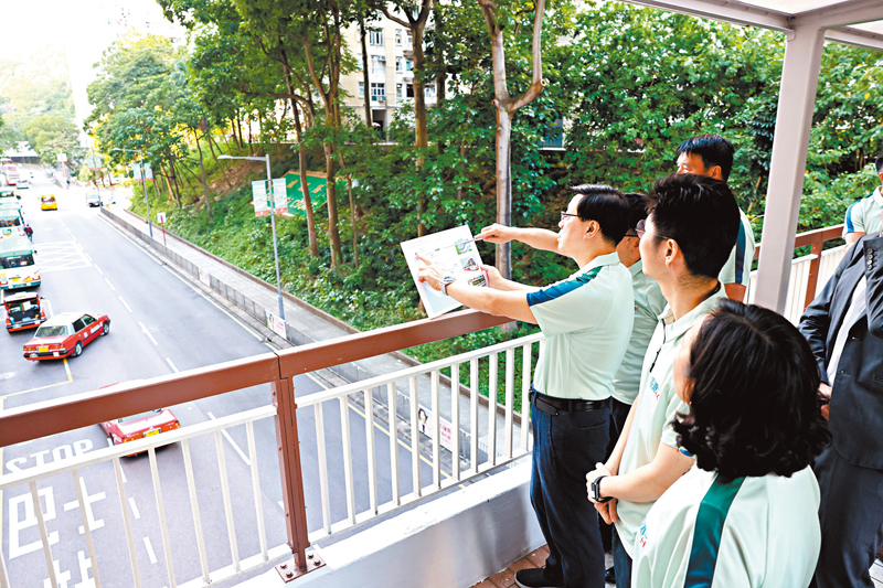 ◆李家超在順利邨行人天橋上，了解東九龍智慧綠色集體運輸系統的規劃走線。香港文匯報記者劉友光 攝