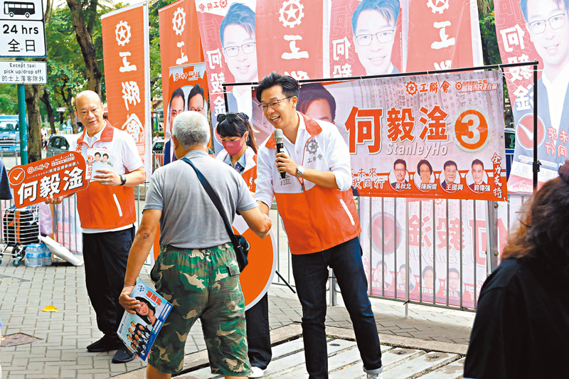 ◆何毅淦與市民握手。 香港文匯報記者北山彥 攝