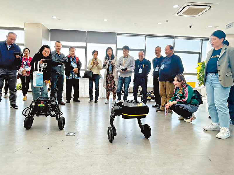 ◆在東莞松山湖，參訪團與本末科技輪式機器人互動。香港文匯報記者敖敏輝  攝