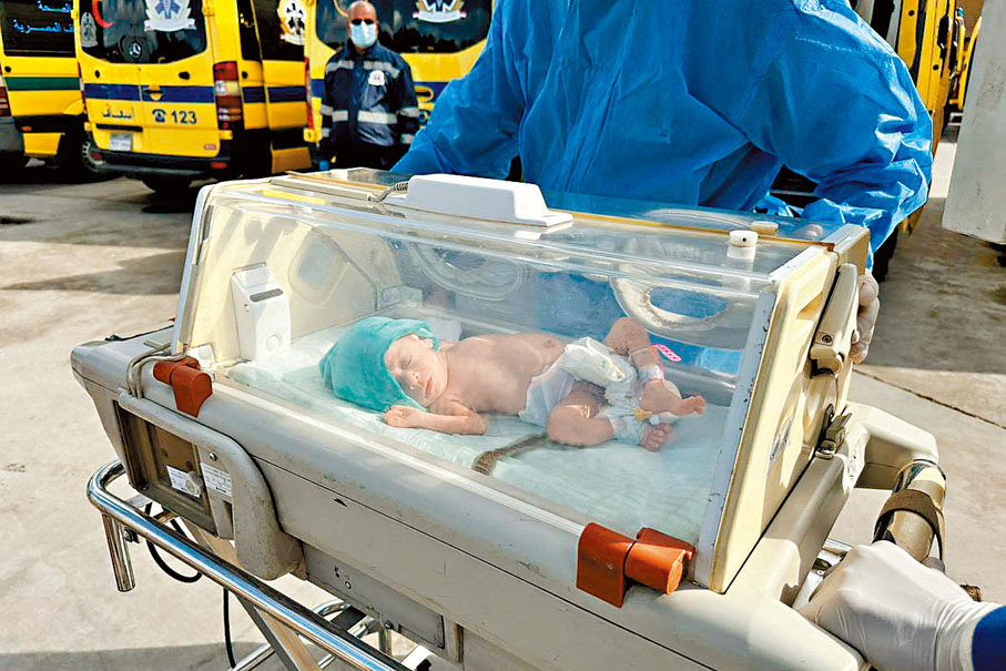 ◆埃及醫護將一名從加沙撤離的早產嬰送到救護車。  法新社