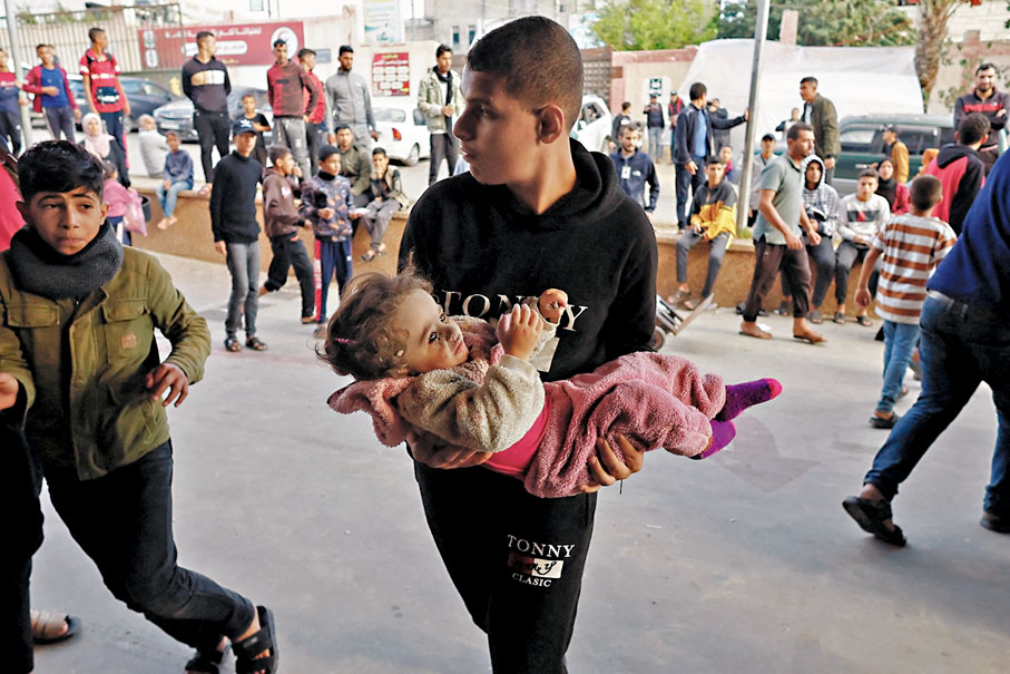◆一名巴人抱着受傷兒童到納賽爾醫院。  路透社