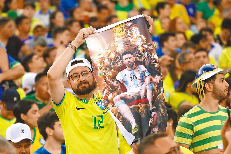 ◆有巴西球迷舉起美斯的畫像。 美聯社