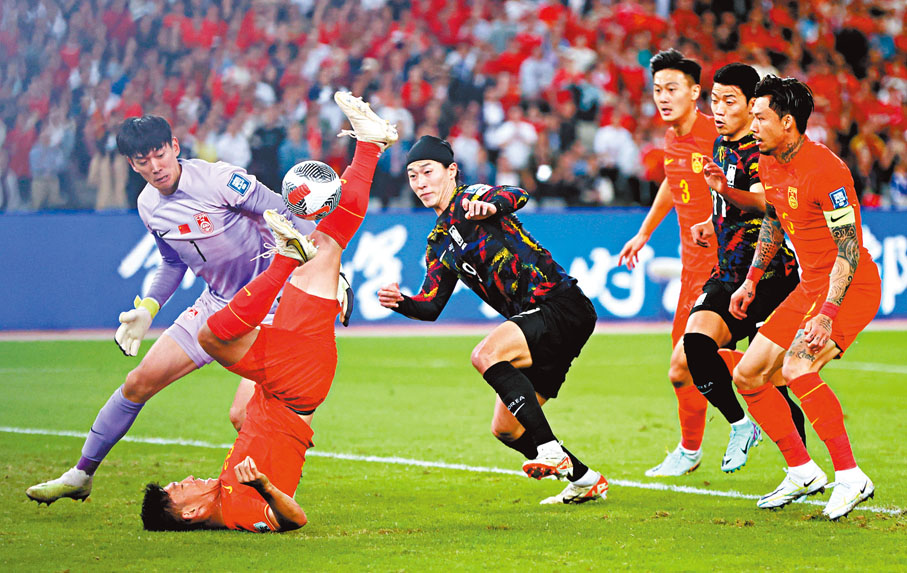 ◆國足（紅衫）球員奮力作戰。  新華社