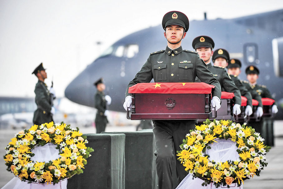 ◆11月23日，在瀋陽桃仙國際機場，禮兵將殮放志願軍烈士遺骸的棺槨從專機上護送至棺槨擺放區。 新華社