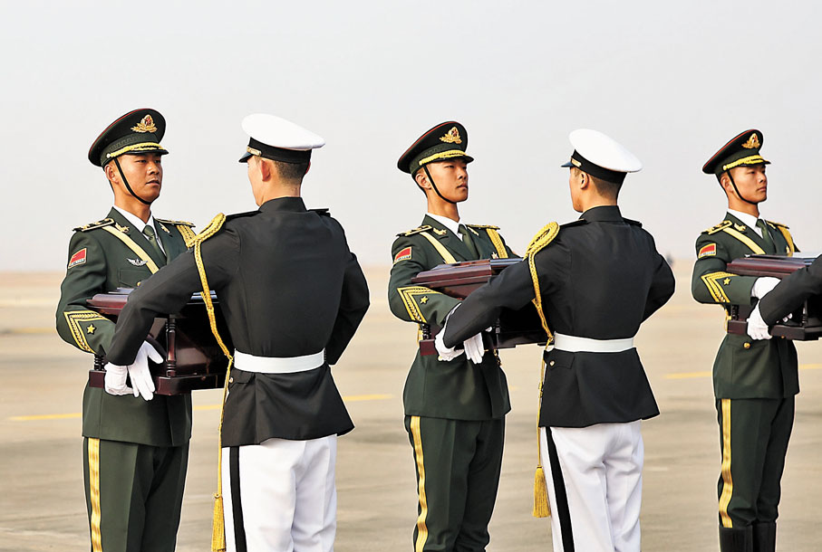◆在韓國仁川國際機場，中國人民解放軍禮兵（左）從韓方接過中國人民志願軍烈士棺槨。 新華社