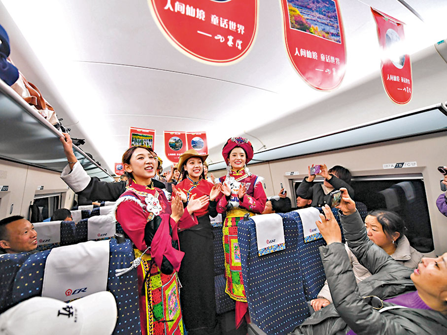 ◆11月28日，在C6008次首發列車上，來自阿壩州民族歌舞團的演員為乘客表演節目。新華社