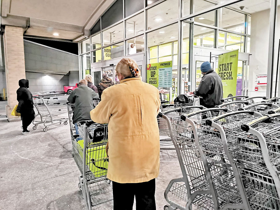 ◆不少人天未光便排隊，等候超市開門後購買減價貨。 成小智 攝