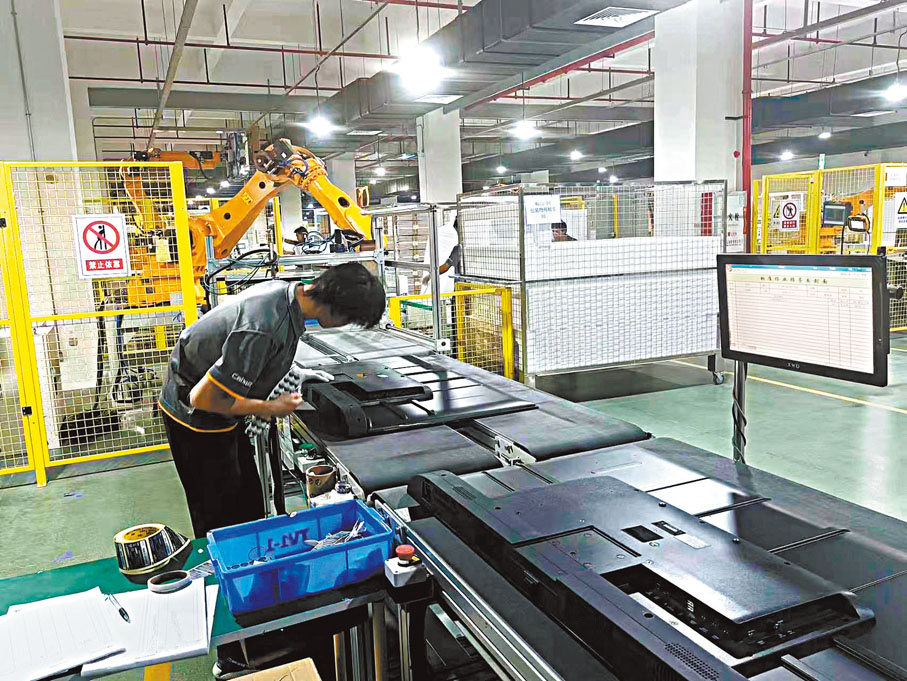 ◆彩迅集團中山工廠員工在給電視裝後蓋。