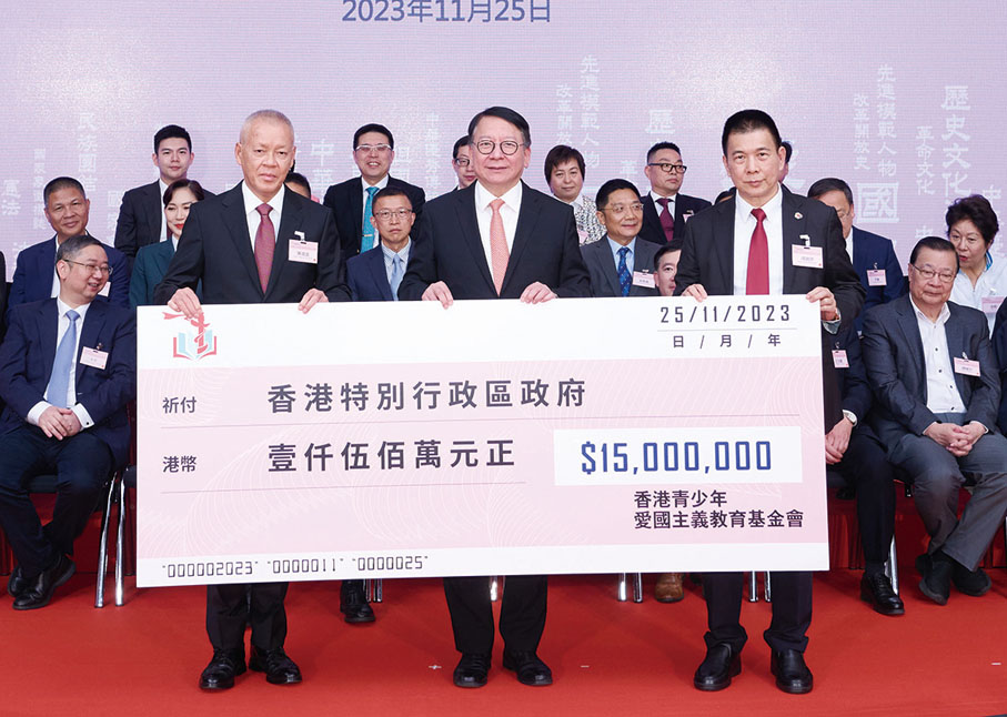 ◆ 陳鴻道（左）及譚錦球（右）遞交支票予陳國基（中）。