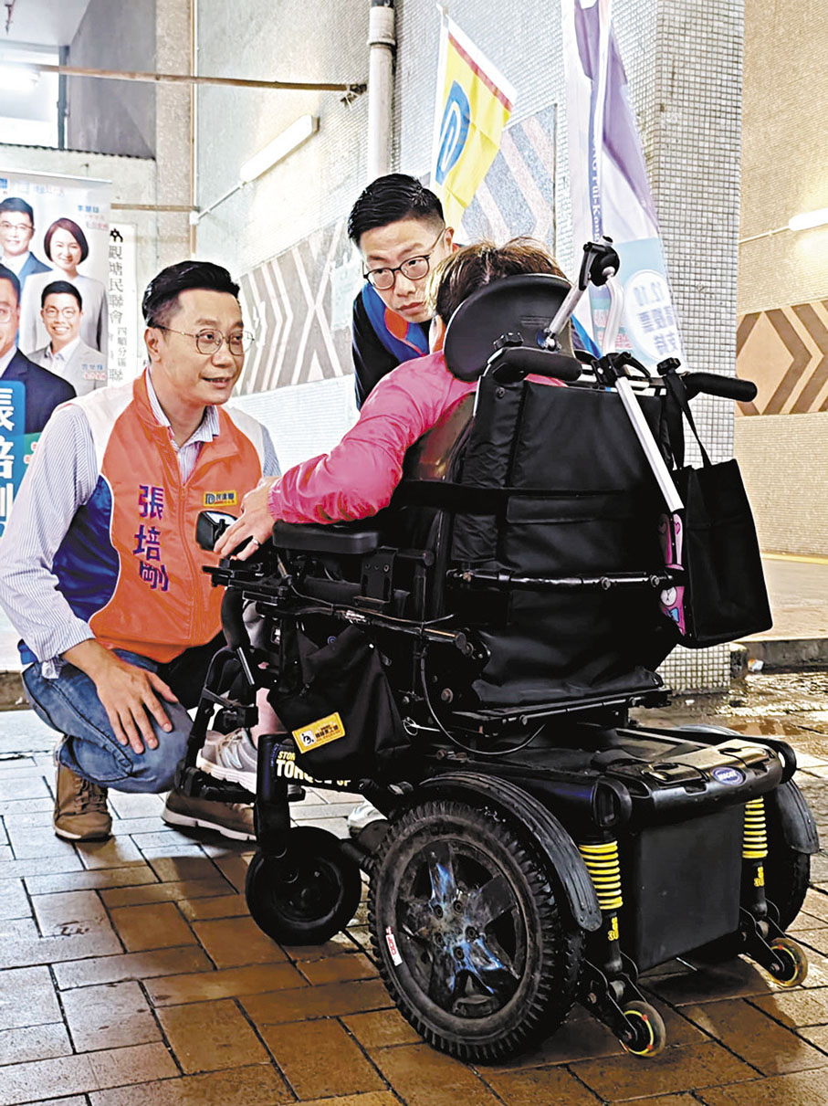 ◆ 張培剛與輪椅人士溝通。