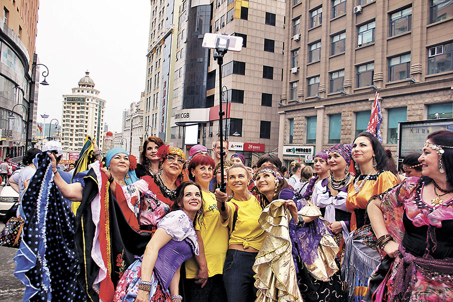 ◆穿上俄羅斯民族服飾的遊客在中國大街上自拍。