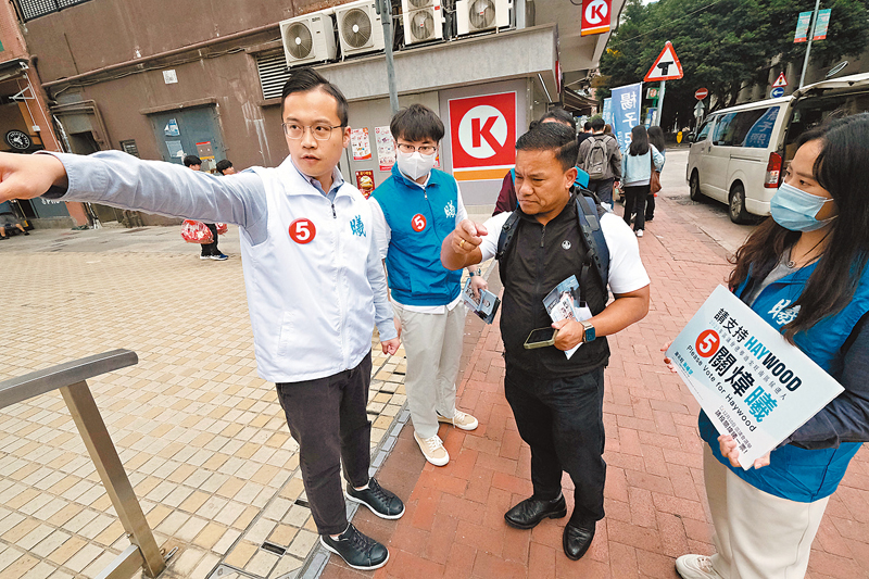 ◆ 關煒曦為街坊解答疑難。香港文匯報記者涂穴 攝