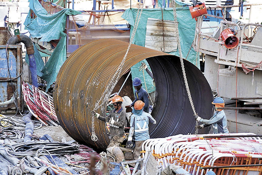 ◆業界正研究吊運有人工智能機制，倘監察到吊運時危險區內有工人，會自行停止運作。圖為工人正準備吊運物件。 資料圖片