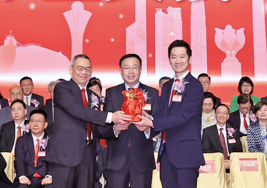 ◆第十六屆理事長李冠華（右）與第十五屆理事長楊毅融（左）在中央政府駐港聯絡辦副主任何靖（中）的見證下進行印鑒交接儀式。