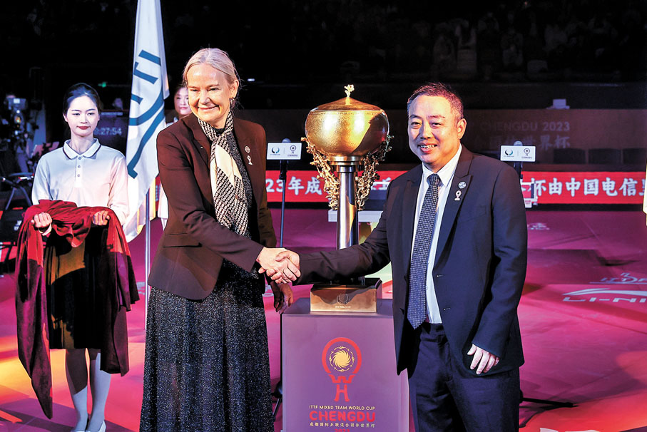 ◆劉國梁（右）和索林在冠軍獎盃前握手留念。 中新社