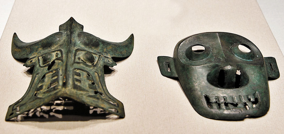 ◆張騫紀念館送展的「商代青銅牛面輔首」（左）和「商代青銅人面輔首」（右）。