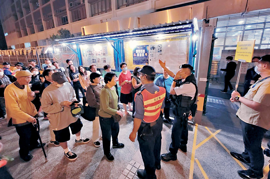 ◆電子選民登記冊系統出現故障後，不少市民在票站外有序輪候進入票站。