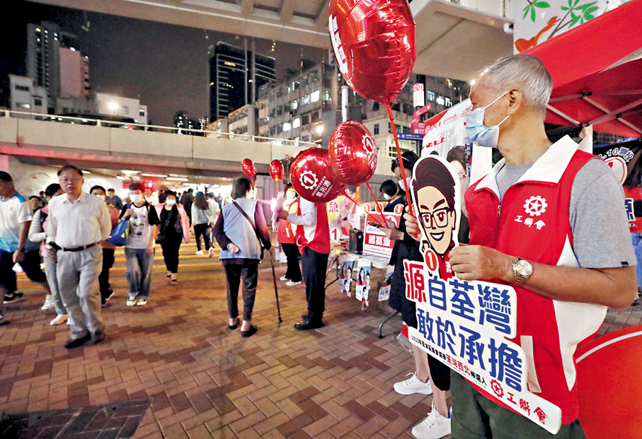 ◆助選義工入夜後仍堅守崗位，繼續為候選人努力拉票。圖為荃灣西北選區。香港文匯報記者郭木又 攝