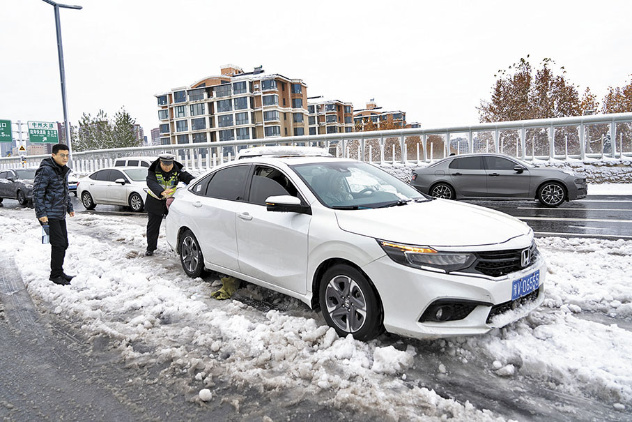 ◆12月11日，河南鄭州，交警救援雪地受困的車輛。鄭州全市按照「機械化除雪為主，人工除雪為輔」的除雪模式，積極開展清除冰雪工作。    中新社
