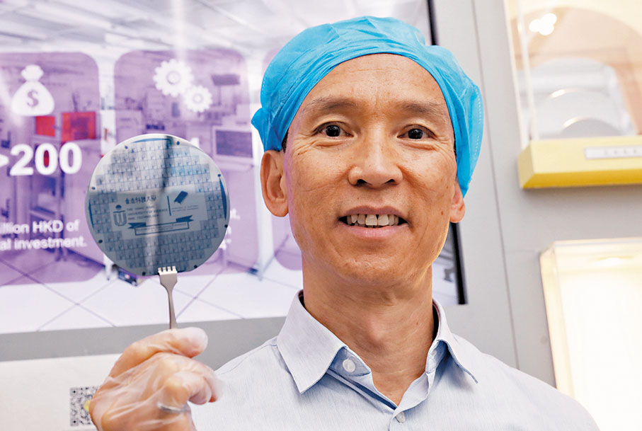 ◆ 單建安展示了科大電子及計算機工程系器件研發項目所製的晶圓，一個晶圓內有多個一式一樣的晶片。香港文匯報記者郭木又  攝