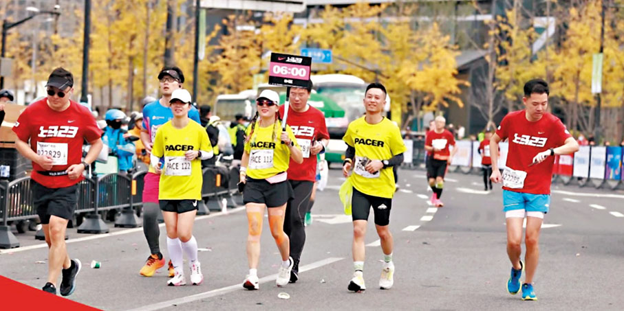 ◆2023上海馬拉松現場，手舉6小時完賽時間指示牌的「關門兔」們與參賽選手們並排奔跑。網上圖片