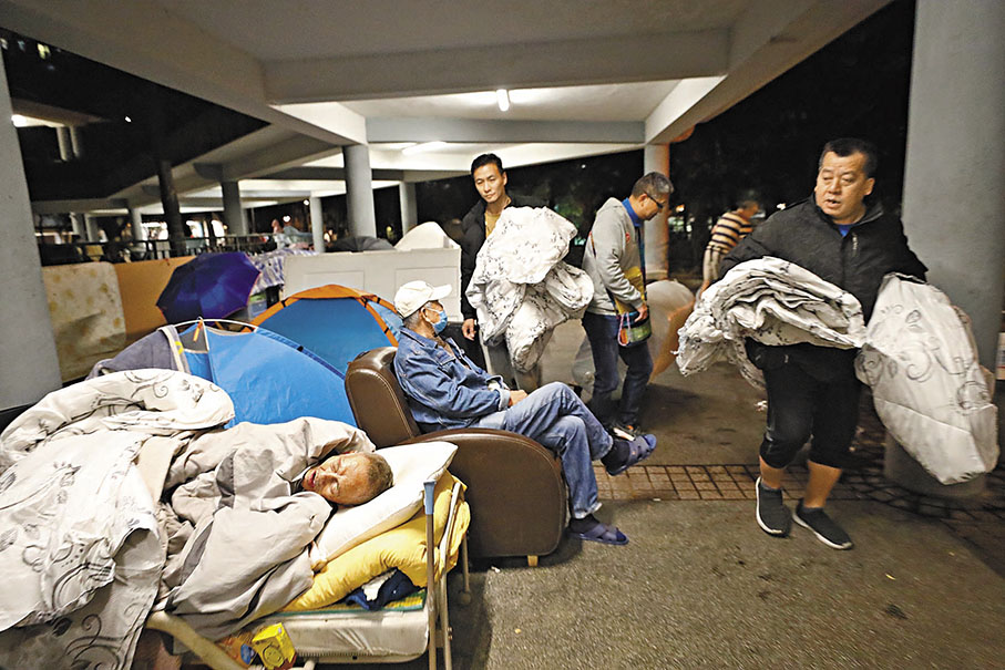 ◆社協義工在通州街公園派棉被予露宿者。 香港文匯報記者萬霜靈 攝