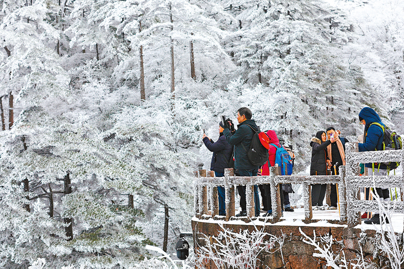 ◆受寒潮天氣影響，安徽省黃山風景區迎來今冬首場降雪。圖為12月16日，遊客在黃山風景區欣賞雪景。 新華社