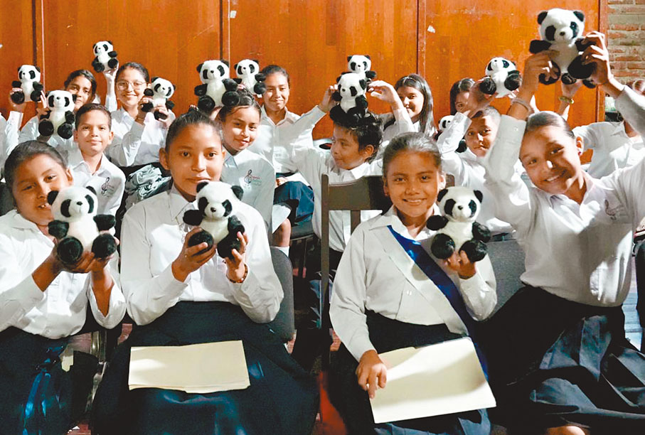 ◆2022年在尼加拉瓜首都馬那瓜的國家劇院裏，參加慶祝中尼復交一周年專場音樂會的學生手捧熊貓玩偶。 網上圖片