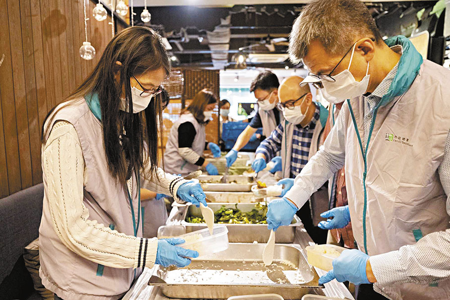 ◆地政總署署長黎志華（右一）和發展局副秘書長（規劃及地政）潘偉榮（右二），與地政總署同事參與派福飯，為有需要長者準備餐膳。 網誌圖片